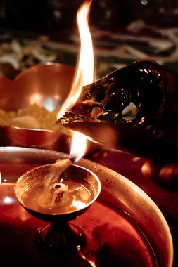 Geleneksel diya, karanlık bir ruhsal atmosferde yağ ve fitil ile yanar. Yakın plan, inanç, miras ve Hint dini uygulamalarını vurguluyor..