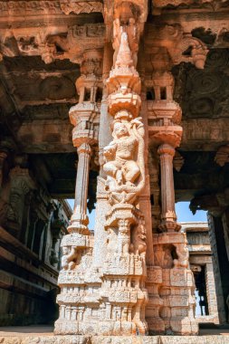 Hampi 'deki entrika oymalı taş sütunlar mitolojik figürler ve Vijayanagara dönemine ait detaylı yardım çalışmaları sergiliyor. Bu mimari başyapıt antik zanaatkarlığı, ruhani sembolizmi ve tapınak sanatını yansıtıyor..