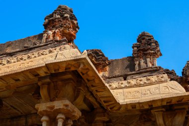 Süslü granit işçiliği ve geleneksel tasarımı olan tarihi Hampi tapınağı yapısının detaylı bir görüntüsü. Görüntü, zamansız Hint mirasını ve arkeolojik dehayı yansıtıyor..