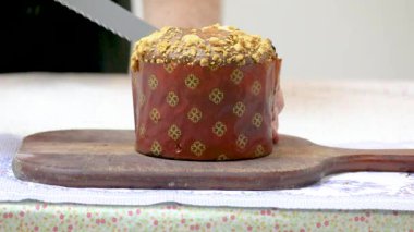 Ev yapımı, doğal mayalanmış bir panettonu Brezilya dokunuşuyla kesiyor, yüzeyinde de gaucho cuca farofa var. Cucatone olarak bilinen dünyada yaratıcı ve benzersiz bir dokunuş..