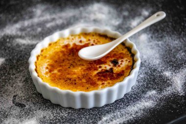 Crme brle, creme brule. Klasik Creme brule alev aldı. Yanan, alevler, lahana, vanilya çekirdeği, pürmüz, şeker, pürmüz.