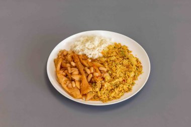 Biftek işkembe, beyaz fasulye ve tropikal baharatlarla hazırlanmış klasik bir Brezilya yemeği, kavrulmuş kasava unuyla servis edilir..