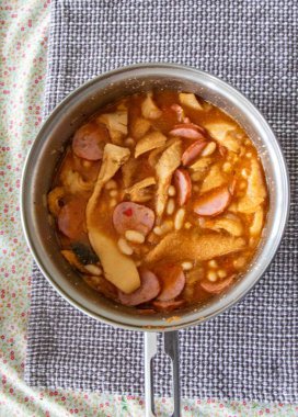 Biftek işkembe, beyaz fasulye ve tropikal baharatlarla hazırlanmış klasik bir Brezilya yemeği, kavrulmuş kasava unuyla servis edilir..