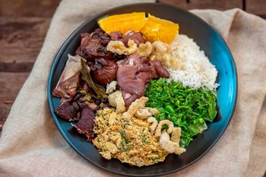 Pirinç, farofa, lahana, portakal, çatırtı ile en iyi, en geleneksel ve gerçek Brezilya feijoadası. Brezilya 'nın Tabak sembolü