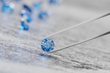 Mavi safir kristal elmas ve cımbızla ışıl ışıl bir zemin üzerinde yumuşak odaklı 3D görüntüleme