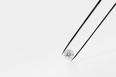 Parlak kristal elmas ve cımbızla beyaz arka plan 3D görüntüleme