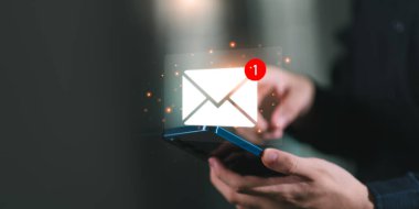 Parlak yeni bir e-posta bildirim simgesi ile akıllı telefonu kontrol eden, dijital iletişimi, e-posta pazarlamasını, çevrimiçi mesajlaşmayı ve iş bağlantıları teknolojisini temsil eden bir kişi.
