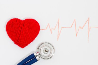 Kırmızı kalp ve steteskop kardiyogram üzerinde dokuma