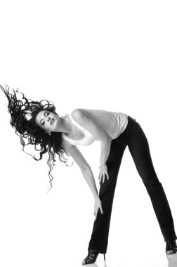 Uzun kahverengi saçlı güzel kadın eğilmiş. Siyah ve beyaz fotoğraf 