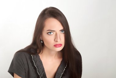 uzun kahverengi saçlı beyaz bir arka plan üzerinde stüdyoda poz güzel bir kadın. üzgün kız 