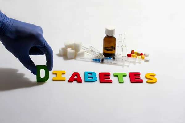 Palavra de mão e diabetes no fundo branco — Fotografia de Stock