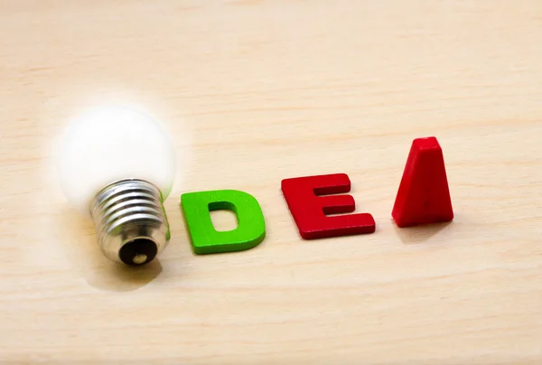 The concept of idea. Lamp and word idea on a wooden background