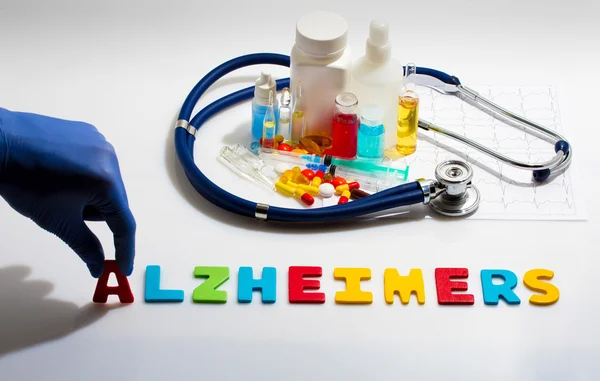 Diagnosis - Alzheimers. Medical concept with pills, injection, stethoscope, cardiogram and a syringe
