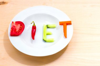 farklı sebze ahşap bir masa üzerinde kelime diyet ile beyaz plaka