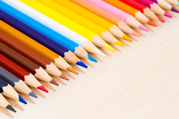 Colorful wooden pencils on wooden background. Selective depth of field