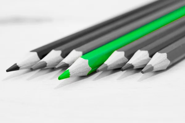 Green separated pencil on the gray background. Selective depth of field — Stock Photo, Image
