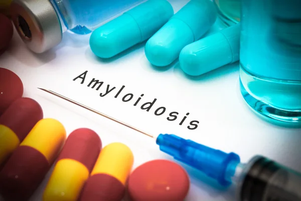 Амилоидоз - диагноз, написанный на белом листе бумаги. Шприц и вакцина с лекарствами — стоковое фото