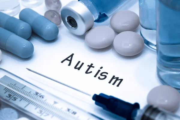 Autismo - diagnosi scritta su un foglio di carta bianco. Siringa e vaccino con farmaci — Foto Stock