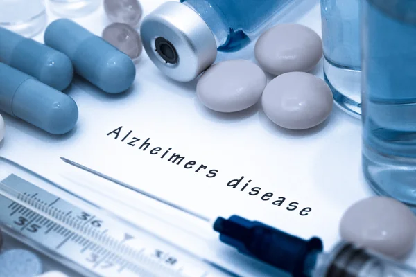 Enfermedad de Alzheimer: diagnóstico escrito en un papel blanco. Jeringa y vacuna con medicamentos . — Foto de Stock