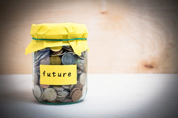 Financial concept. Coins in glass money jar with future label. Wooden background — Stock Photo, Image