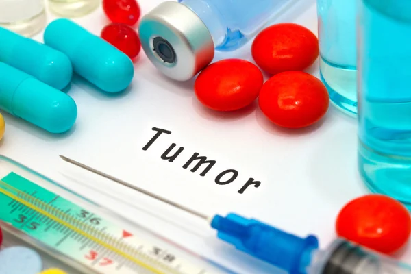Tumör - diagnos skriven på ett vitt papper. Sprutan och vaccin med droger — Stockfoto