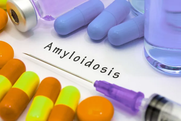 Амилоидоз - диагноз, написанный на белом листе бумаги. Шприц и вакцина с лекарствами — стоковое фото