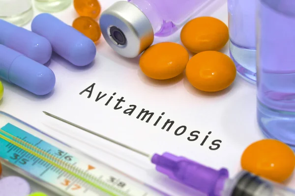 Avitaminosis - diagnóstico escrito en un papel blanco. Jeringa y vacuna con medicamentos — Foto de Stock