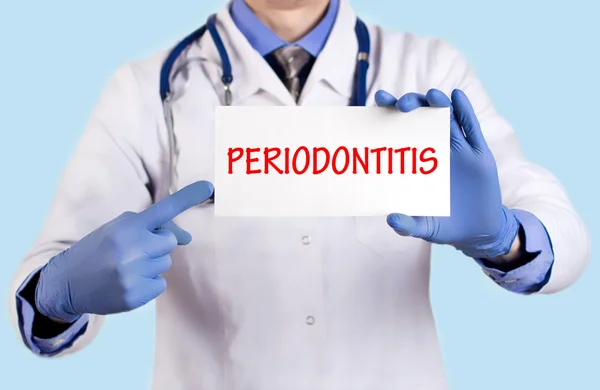 Le médecin conserve une carte avec le nom du diagnostic - parodontite — Photo