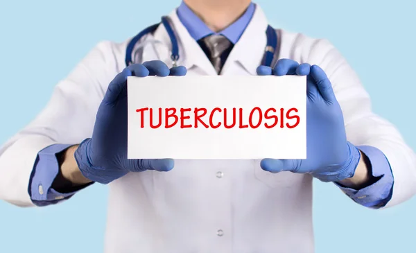 O doutor guarda um cartão com o nome do diagnóstico - tuberculose — Fotografia de Stock