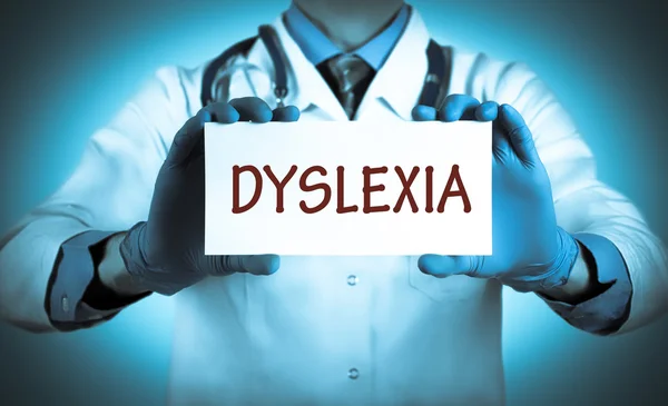 Лікар тримає карту з назвою діагнозу дислексія — стокове фото