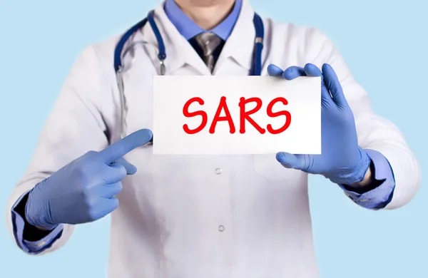 O doutor guarda um cartão com o nome do diagnóstico - sars — Fotografia de Stock