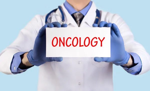 Läkare håller ett kort med namnet på diagnosen-onkologi — Stockfoto