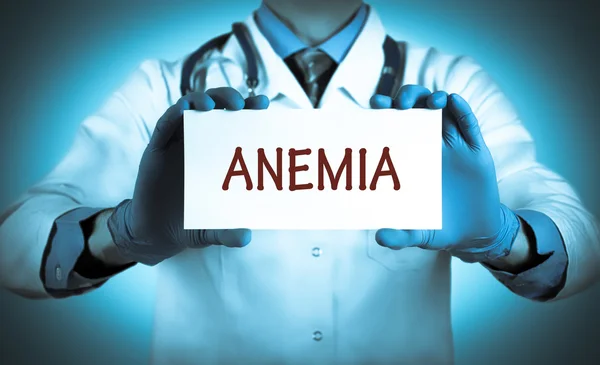 Il dottore tiene una carta con il nome della diagnosi - l'anemia — Foto Stock