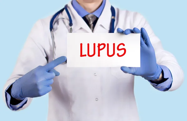 El médico guarda una tarjeta con el nombre del diagnóstico - lupus — Foto de Stock