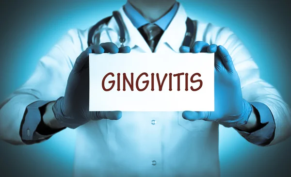 O doutor guarda um cartão com o nome do diagnóstico - gengivite — Fotografia de Stock