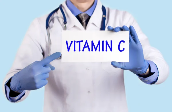 El doctor guarda una tarjeta con el nombre de la vitamina C — Foto de Stock