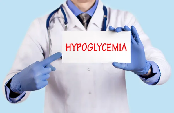 Arts houdt een kaart met de naam van de diagnose-hypoglycemie — Stockfoto