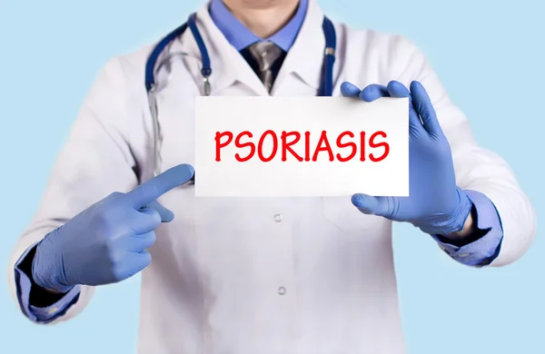 O doutor guarda um cartão com o nome do diagnóstico - psoríase — Fotografia de Stock