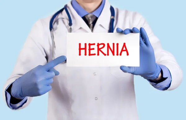 O doutor guarda um cartão com o nome do diagnóstico - hérnia — Fotografia de Stock