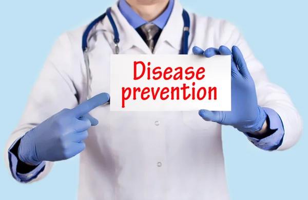 Il dottore tiene una carta con il nome della diagnosi - la prevenzione di malattia — Foto Stock