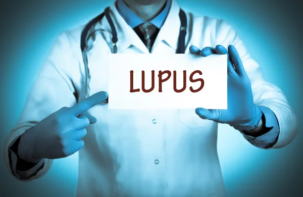 El médico guarda una tarjeta con el nombre del diagnóstico - lupus — Foto de Stock