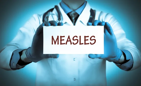 Doctor keeps a card with the name of the diagnosis - measles — Stock Photo, Image