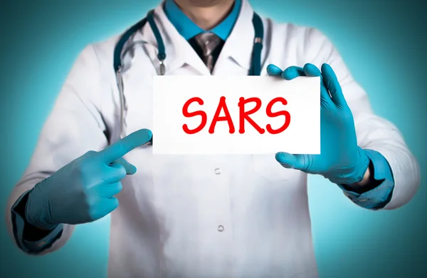 O doutor guarda um cartão com o nome do diagnóstico - sars — Fotografia de Stock