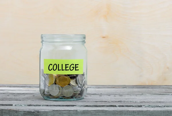 Label on a glass jar with the inscription - college. Glass jar with coins. Financial concept on wooden background — Stock Photo, Image