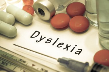 Disleksi - beyaz bir kağıt parçası üzerinde yazılı tanı. Şırınga ve uyuşturucu ile aşı