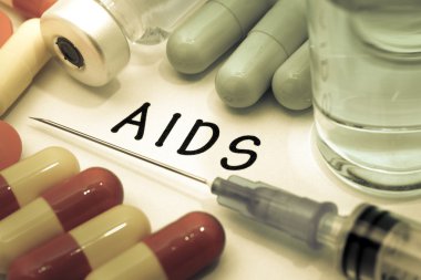 AIDS - beyaz bir kağıt parçası üzerinde yazılı tanı. Şırınga ve uyuşturucu ile aşı.