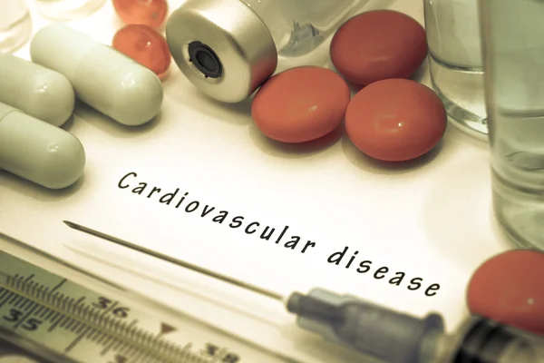 Boala cardiovasculară - diagnostic scris pe o bucată albă de hârtie. Seringă și vaccin cu medicamente . — Fotografie, imagine de stoc