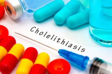 Cholelithiasis - beyaz bir kağıt parçası üzerinde yazılı tanı. Şırınga ve uyuşturucu ile aşı