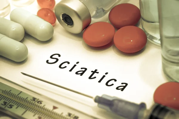 Sciatica - diagnóstico escrito en un pedazo de papel blanco. Jeringa y vacuna con medicamentos . —  Fotos de Stock