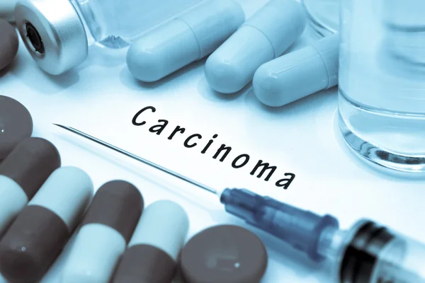 Carcinoma: diagnóstico escrito en un papel blanco. Jeringa y vacuna con medicamentos — Foto de Stock